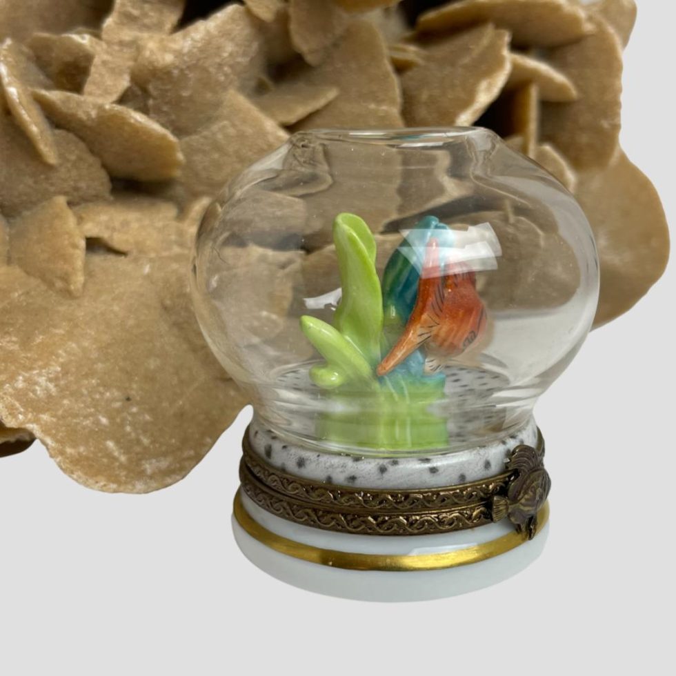 Photo of Limoges goldfish bowl box with the fish now appearing to be swimming away to the right so only its tail is really visible. The green seaweed is on this side.