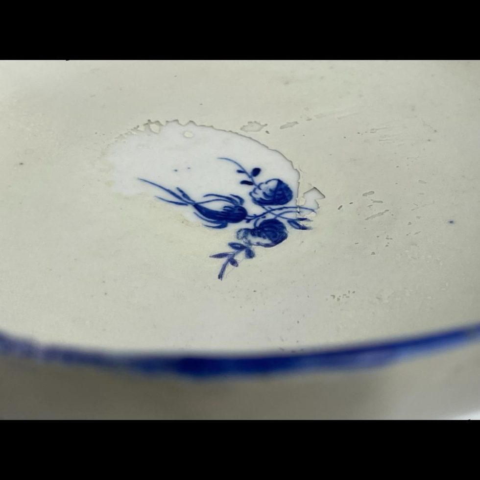 Close up photo of the wear to the centre of the saucer of Caughley chocolate cup & saucer . It appears as though there was a painted repair which has peeled away. Thankfully the cup covers this area !