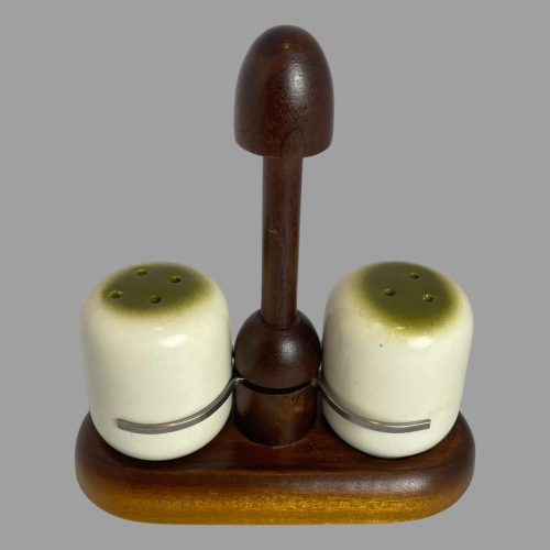 Main photo of Alvar Aalto salt and pepper seen nearly from an eye level - just slightly raised to show the matcha green coloured tops. The pots are situated in their slots on the stand. The handle for the stand is at the centre & looks like an unopened chocolate mushroom while the salt and pepper pots are like white chocolate with matcha powder glaze tops.