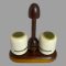 Main photo of Alvar Aalto salt and pepper seen nearly from an eye level - just slightly raised to show the matcha green coloured tops. The pots are situated in their slots on the stand. The handle for the stand is at the centre & looks like an unopened chocolate mushroom while the salt and pepper pots are like white chocolate with matcha powder glaze tops.