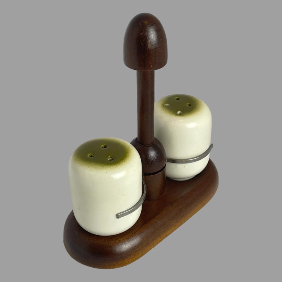 Photo of Alvar Aalto salt & pepper still displayed on their stand this time the stand is posed diagonally across the square page so one end is pointing to the bottom left corner and other opposite in top right.