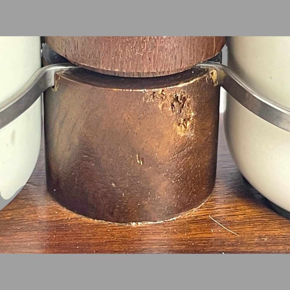 A close up photo of some of the wear to the lower area of the stand handle below the metal holders for the pots.