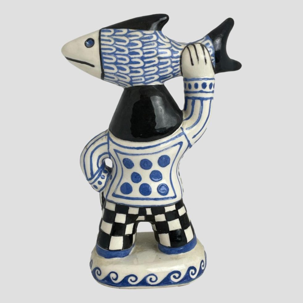 Photo of the back of Bernard Moss fisherwoman figure. The fish is facing left