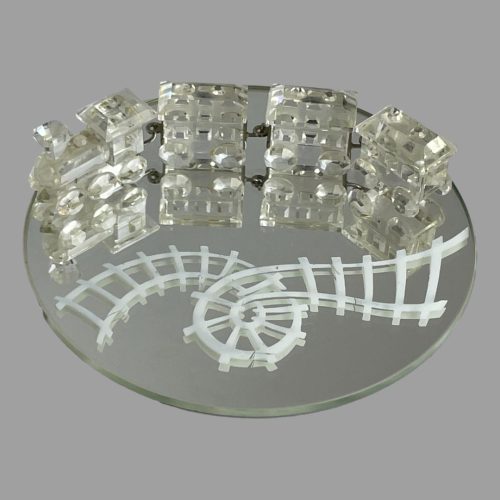Main photo of Swarovski crystal train set displayed with the train on top of the round mirror with the track (which is painted) in the foreground. The track is very Willy Wonka with a twirl in the centre . The engine of the train is at the left with the carriages attached in a row behind it.