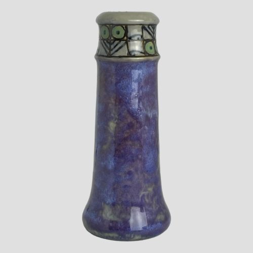 Main photo of small Doulton chimney vase seen from an eye level. The main body of the vase is a stunning mixed shade of lapis lazuli blue and amethyst purple with flecks of green. Around the top of the vase (about 2inches) is a grey green stone colour with a lovely simple design in piped black with green circles. To me, these look like cartoon characters of birds (green balls at top, beak below) or cat (green balls for eyes at bottom triangles above like ears. There are also fish like forms between the bird/cat images that I can see)