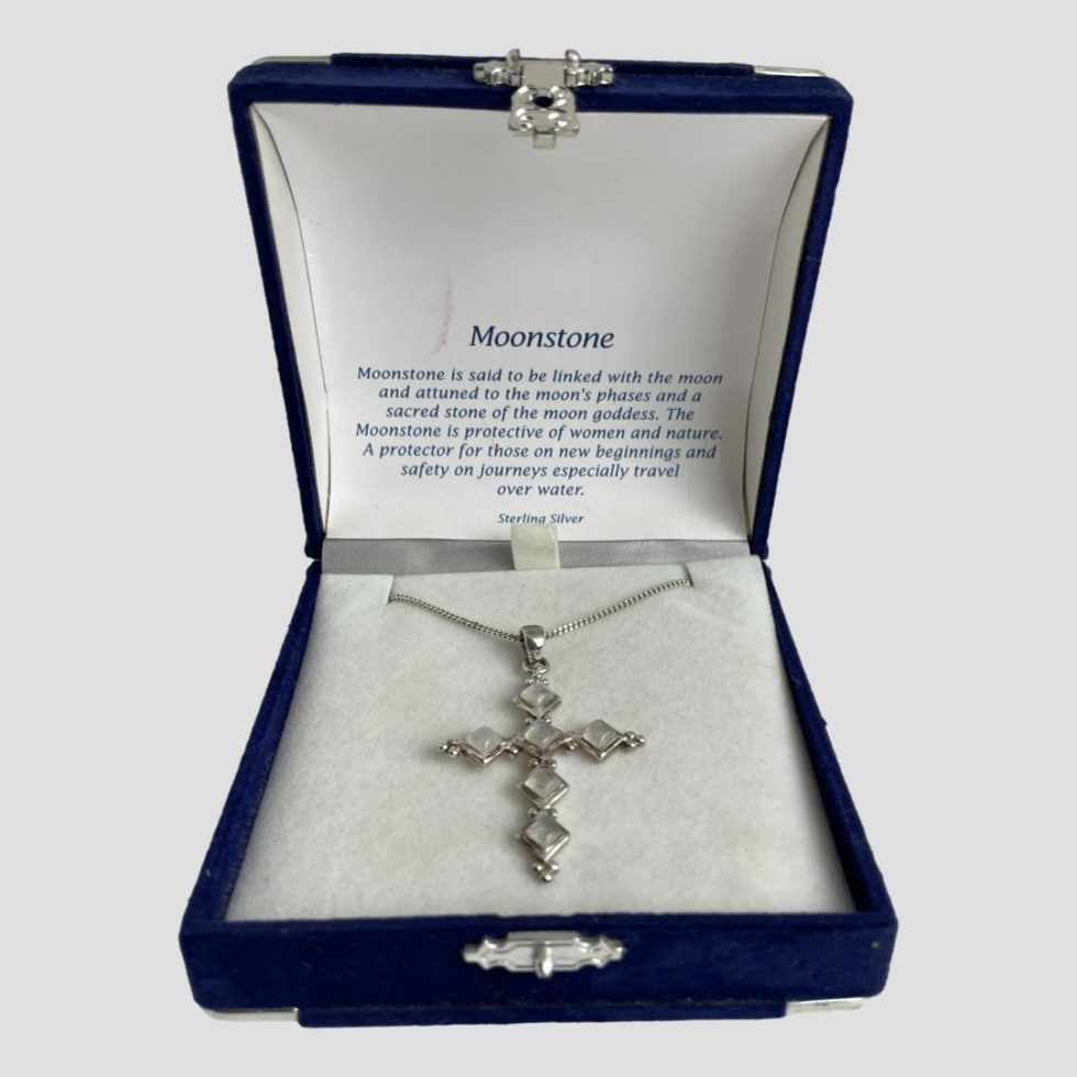 Photo of silver moonstone cross &chain displayed inside its special box with the benefits of moonstone card visible inside the lid.