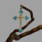 Main photo of antique 18 karat gold cross displayed hanging from a twig of natural cherry wood. The cross is forward facing. The 4 tips of the cross has 3 pointed tips housing 3 small beautiful turquoise blue Sleeping Beauty stones. One stone to pointed tip and 2 immediately behind. 18 seed pearls adorn the rest of the cross. A very pretty piece c1880.
