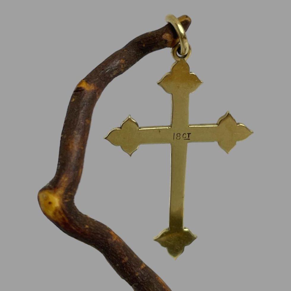 Photo of antique 18 karat gold cross still hanging from twig of natural cherry wood this time displaying the back of the cross showing the 18ct hallmark.